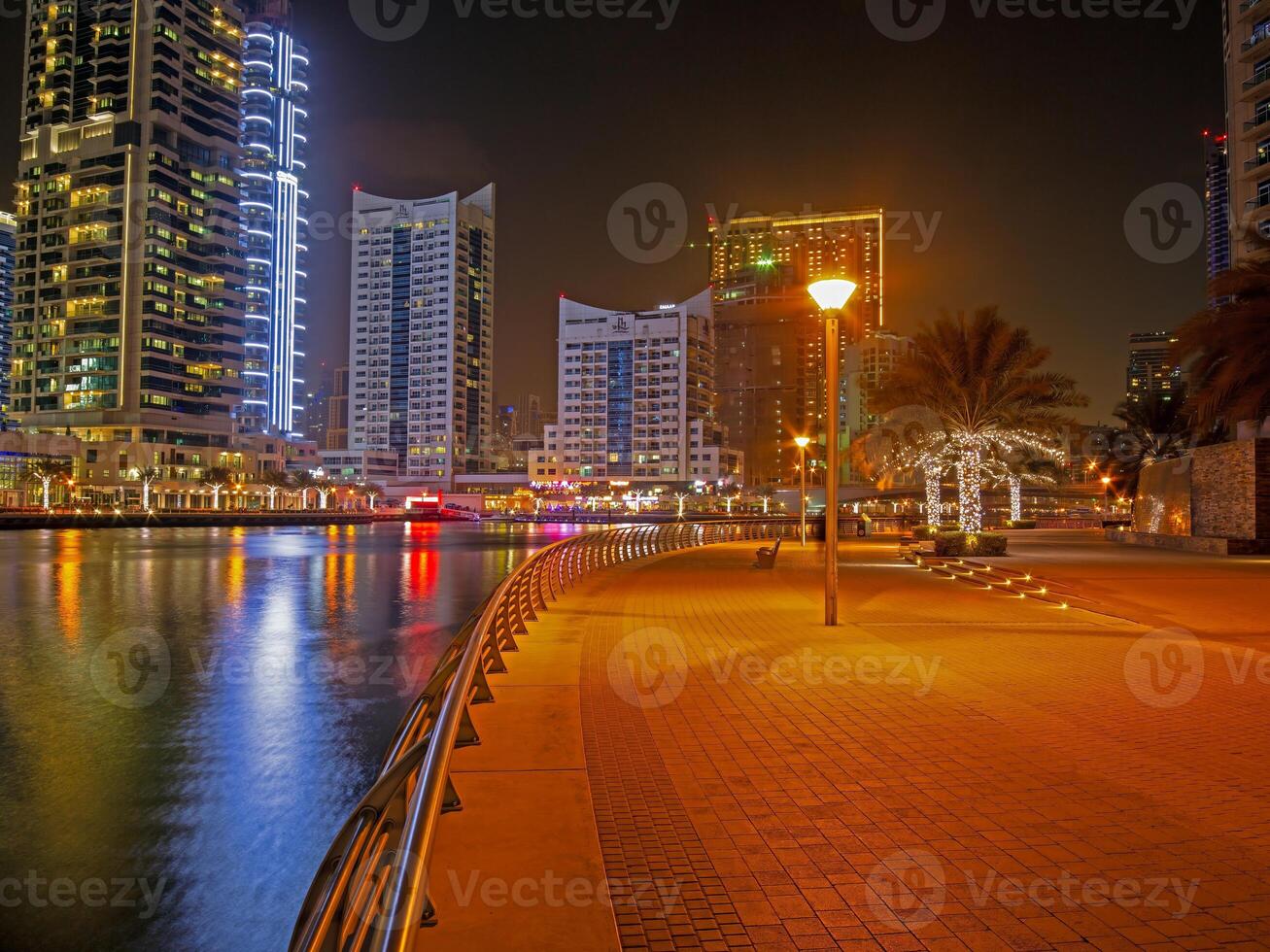 Panoramic night view of Dubai Marina skyline with waterfront reflections d photo