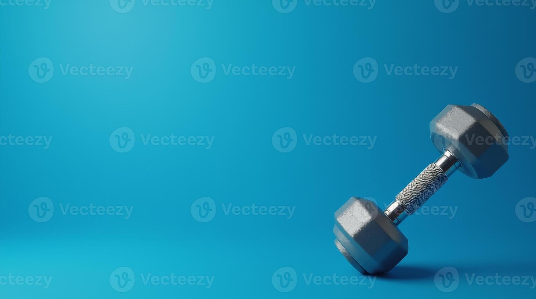 Gray dumbbell with textured metal handle placed on blue background, fitness concept for gym, strength training, and healthy lifestyle design with copy space photo