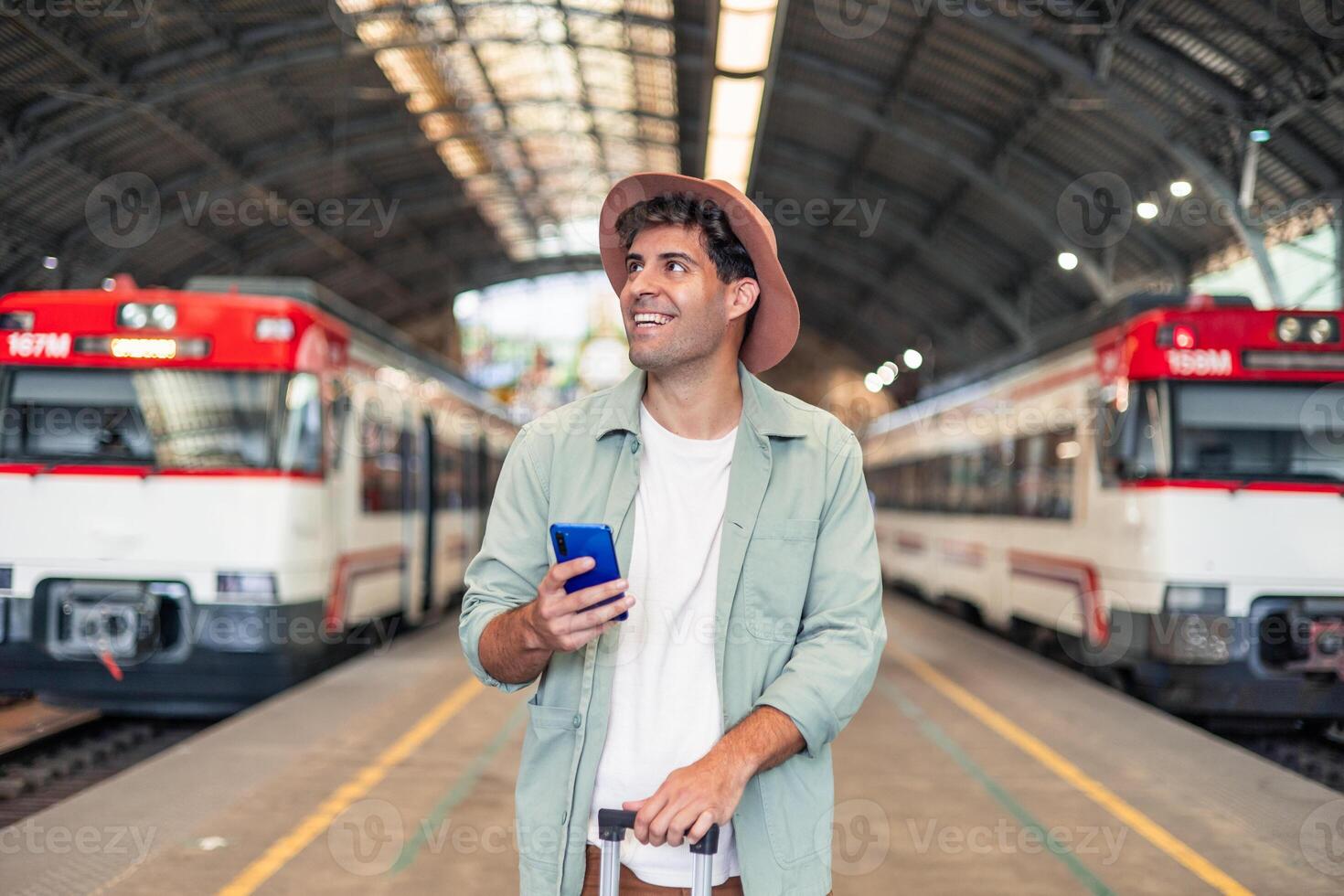 closeup latin Tourist holding smartphone and suitcase is waiting for train at station photo