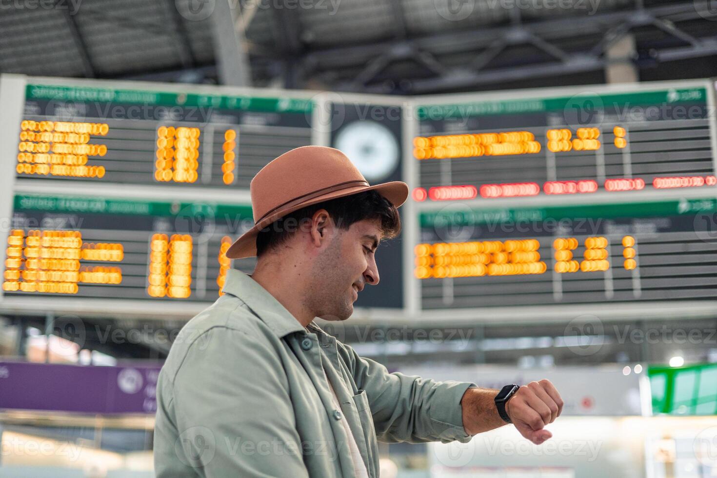 latin Tourist checking time in front of timetable display at train station photo