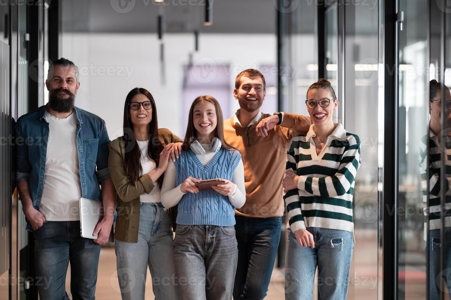 A diverse team of professionals in a modern coworking startup office smiles together, showcasing teamwork, collaboration, and a positive corporate culture that promotes innovation and a dynamic work photo