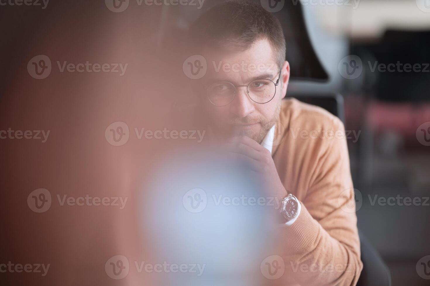 Smart looking focused businessman working on a laptop and thinking. Millennial managing family budget, handling financial paperwork, and tracking expenditures on a laptop at a modern open space office photo