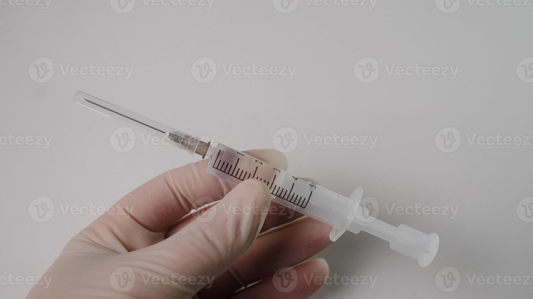 A hand holding a syringe filled with liquid, showcasing medical equipment for health and vaccination. photo