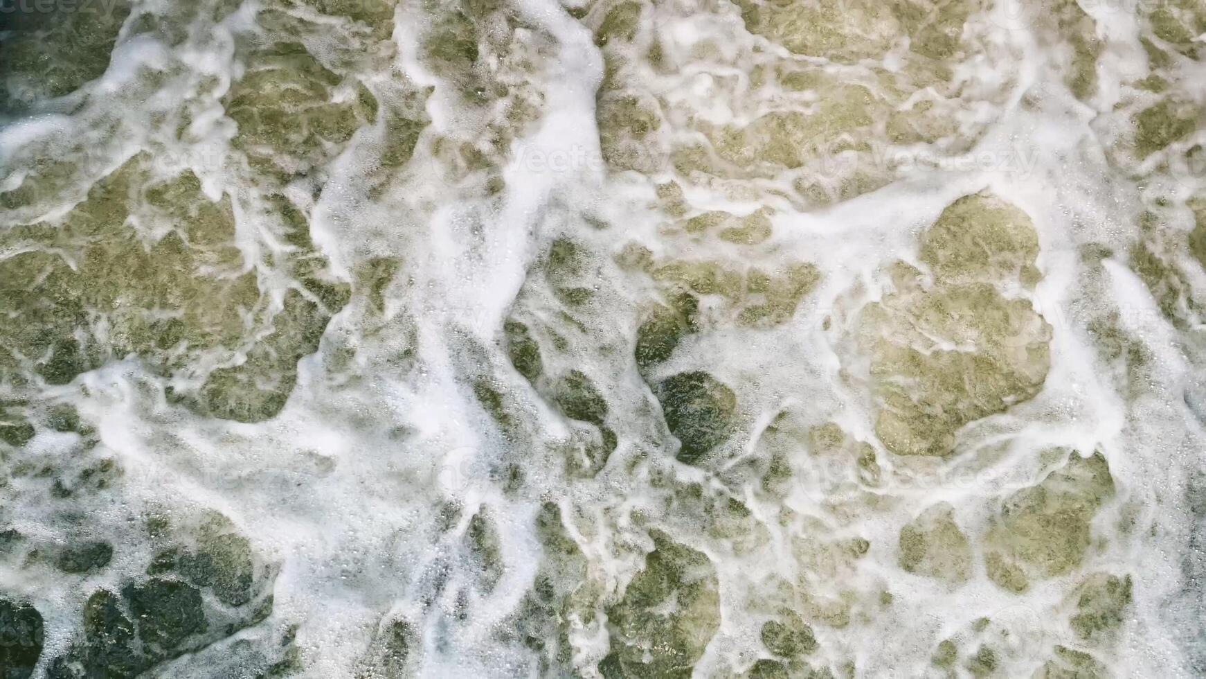 A stunning aerial view showcases the turbulent ocean waves that create a mesmerizing pattern of foam photo