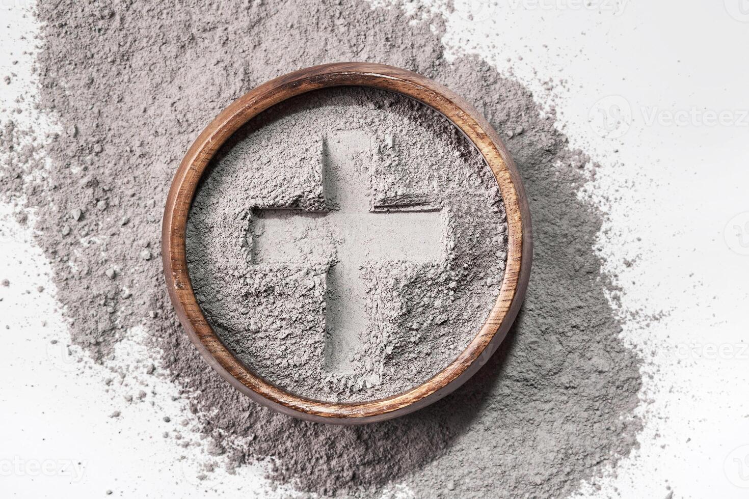 Cross imprint in gray ash on white background. Ash Wednesday photo