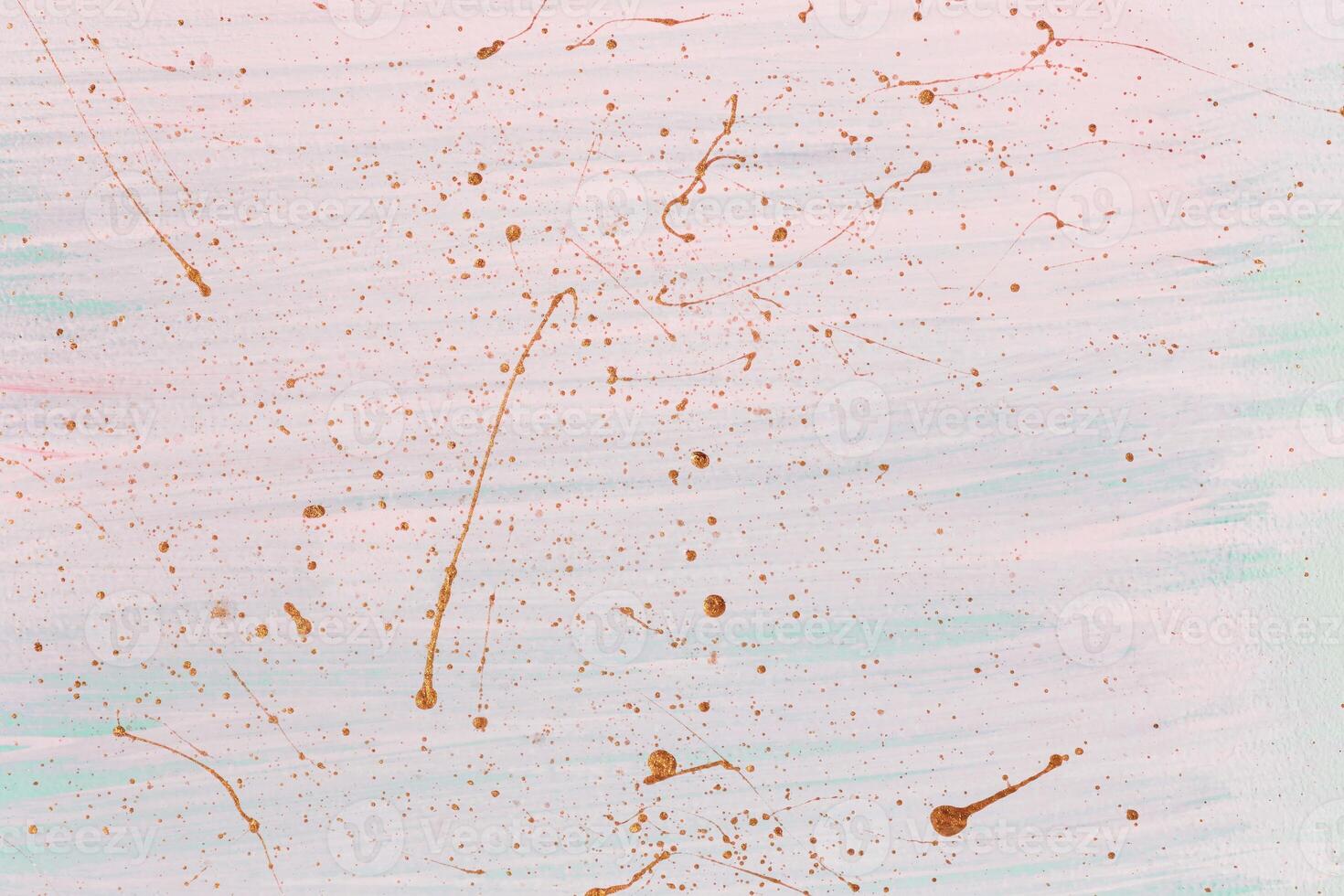 Golden splashes and drops on pink pastel background. Hand painted background or texture for your design photo