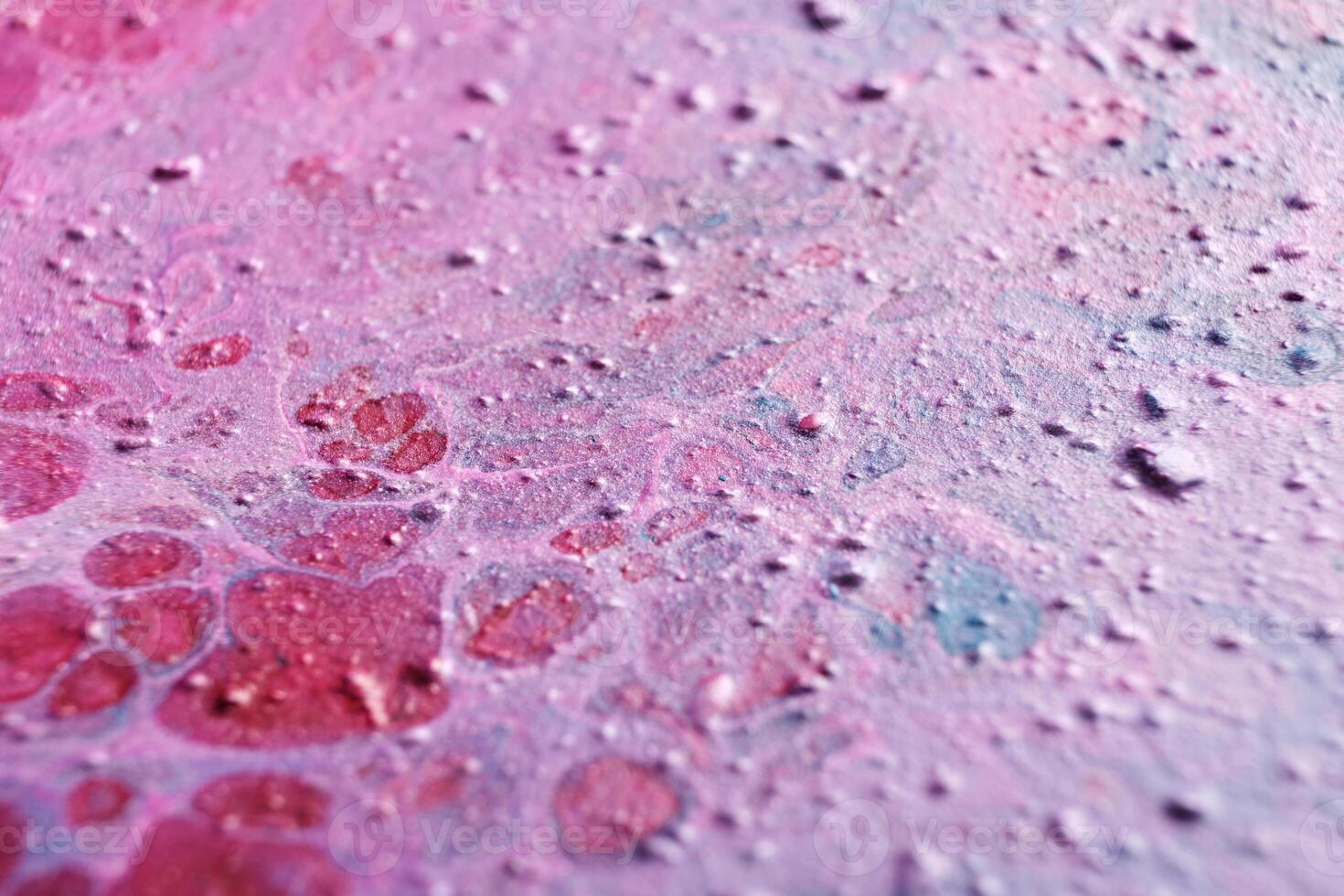 Fluid Art. Embossed strokes, craters and drips of pink paint. Marble effect background or texture. Selective focus photo