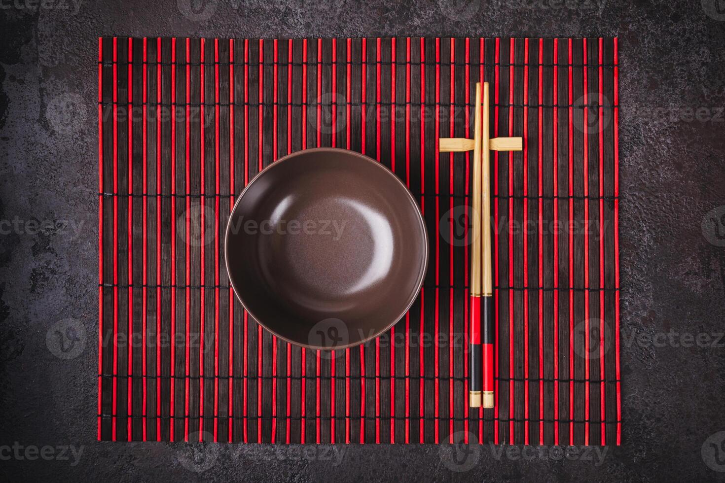 Asian Japanese table setting. Bamboo chopsticks and bowl on striped mat photo