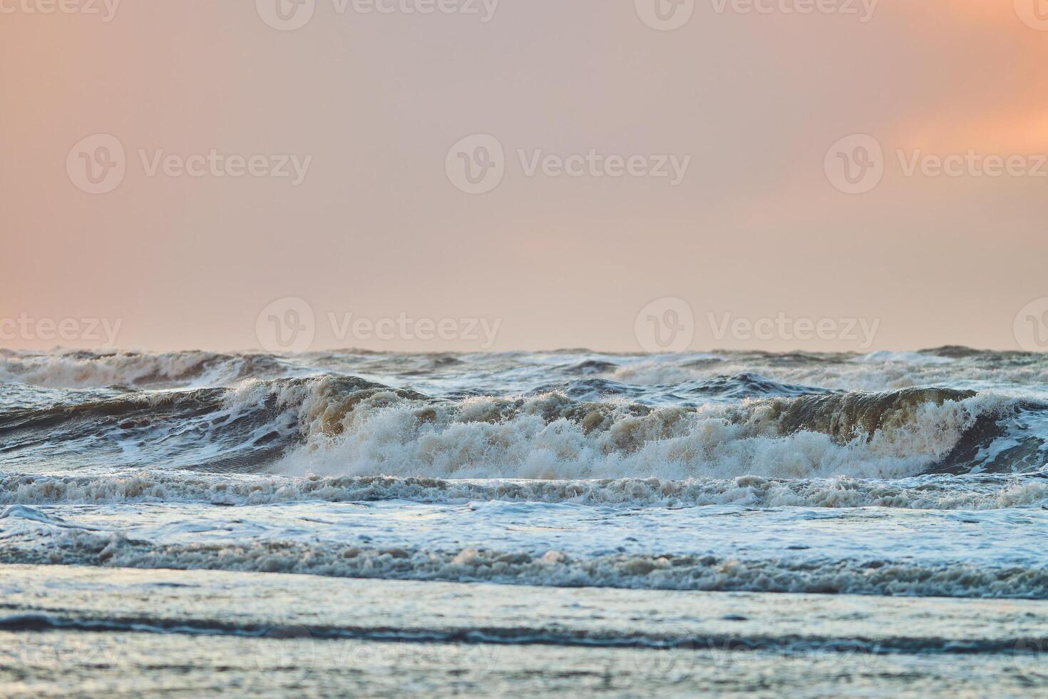 Sunset over north sea waves at danish coast photo