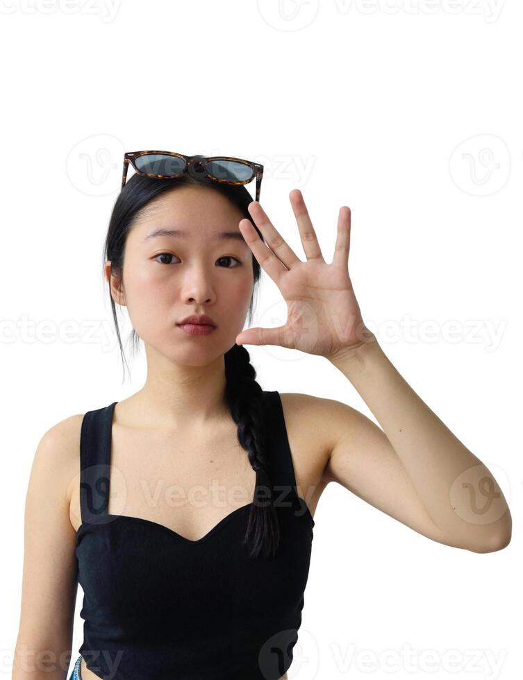 A woman with sunglasses and a black top is making a stop sign photo