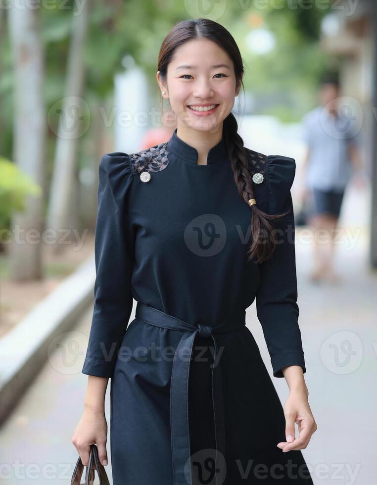 A woman in black dress and black shoes walking down the street photo