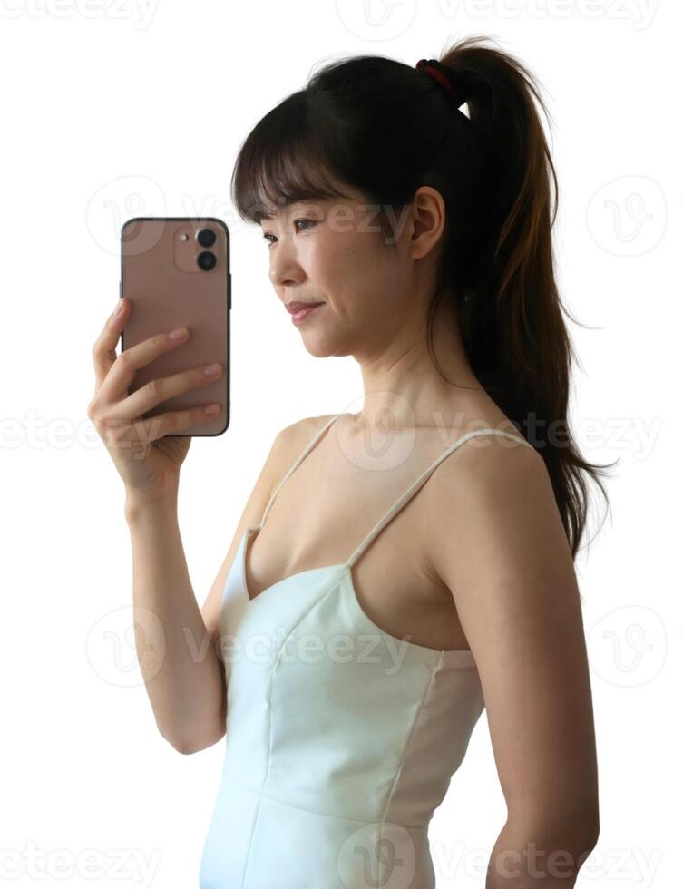 A woman in a white dress holding up her phone photo