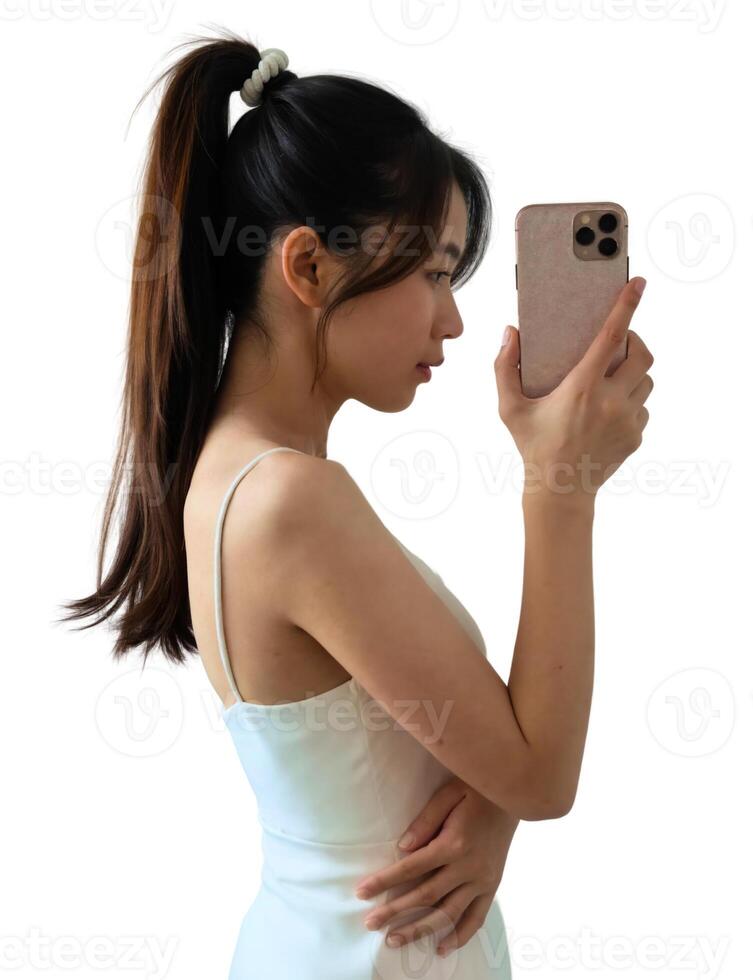 A woman holding a cell phone while looking at herself in the mirror photo