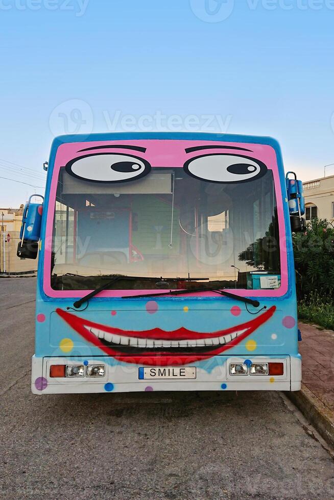 Cheerful school bus with painted funny face and smile photo