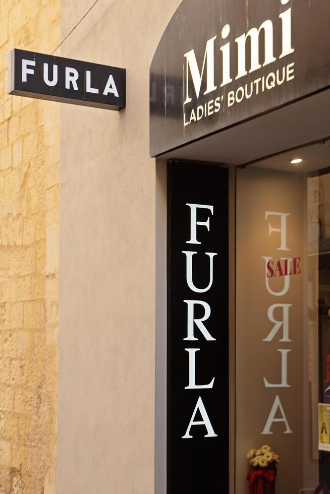 Valletta, Malta - February, 2025. Furla and Mimi Ladies Boutique signage in Historic Shopping Alley in Valletta photo