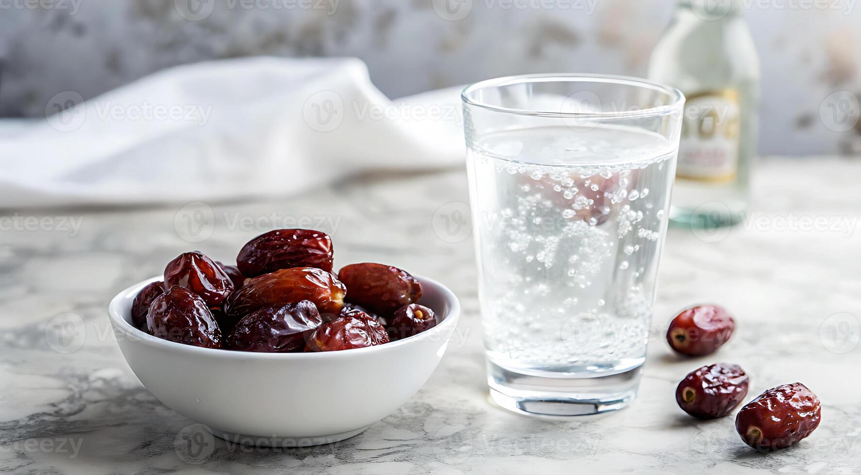 A bowl of dates and a glass of water photo