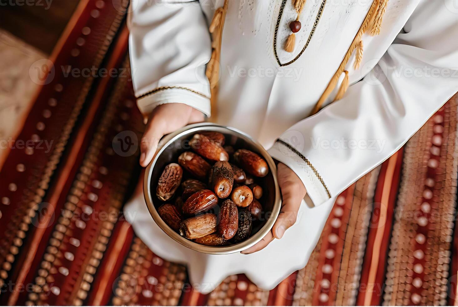 A person in a white robe holding a bowl of dates photo