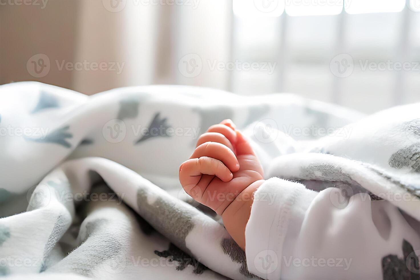 A baby's hand is wrapped in a blanket photo