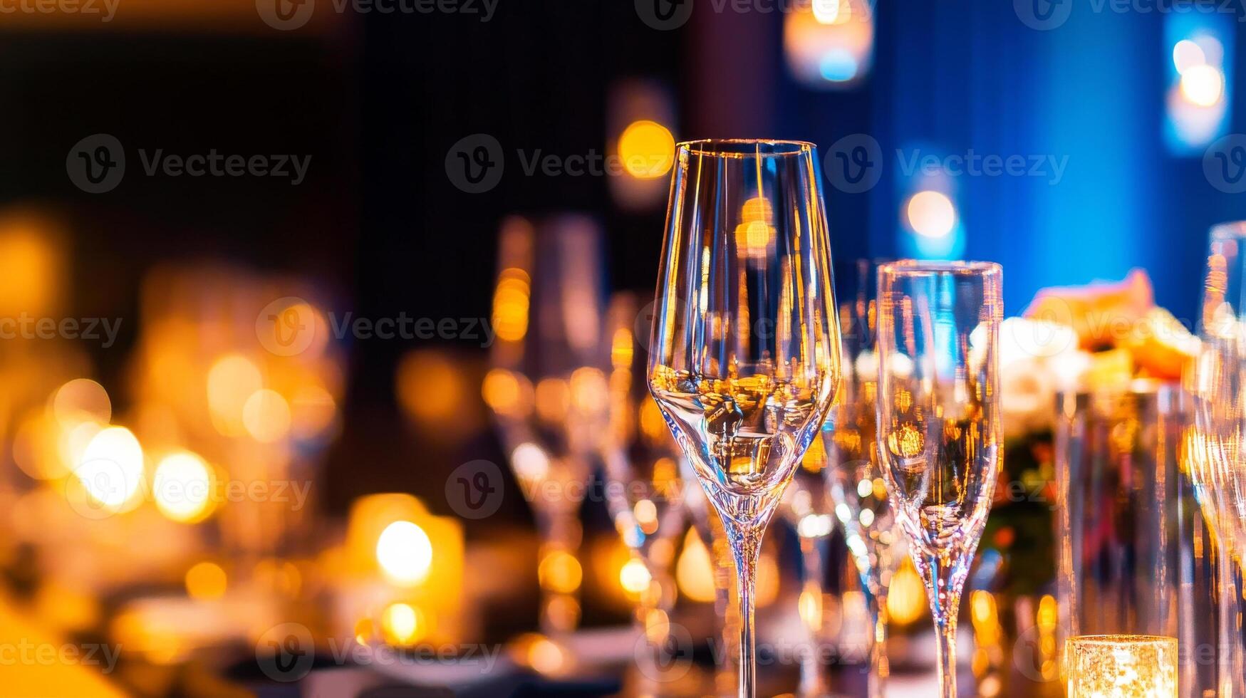 A table with many wine glasses and candles photo