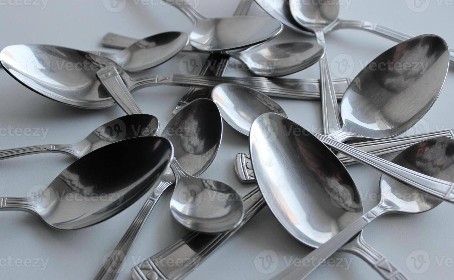 Pattern of spoons of different sizes scattered on a plastic cutting board photo