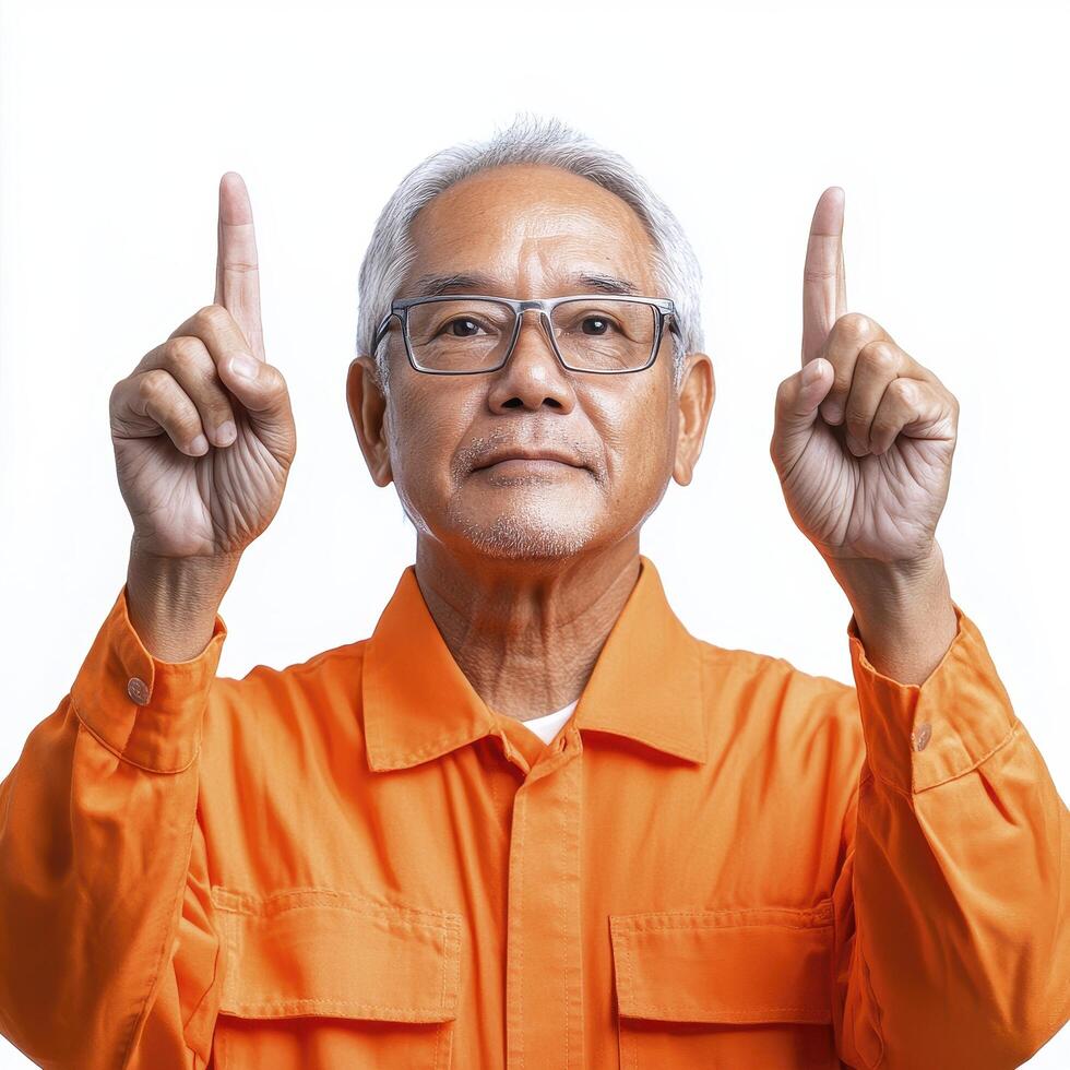 Senior Man in Orange Jumpsuit Pointing Upward photo