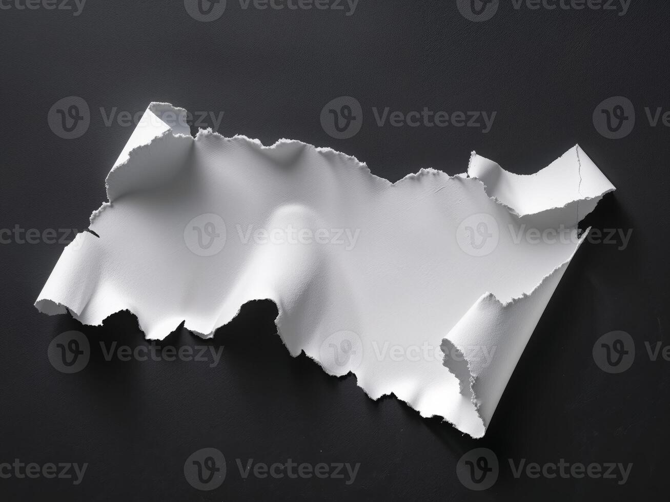 A piece of paper with torn edges on a black surface photo