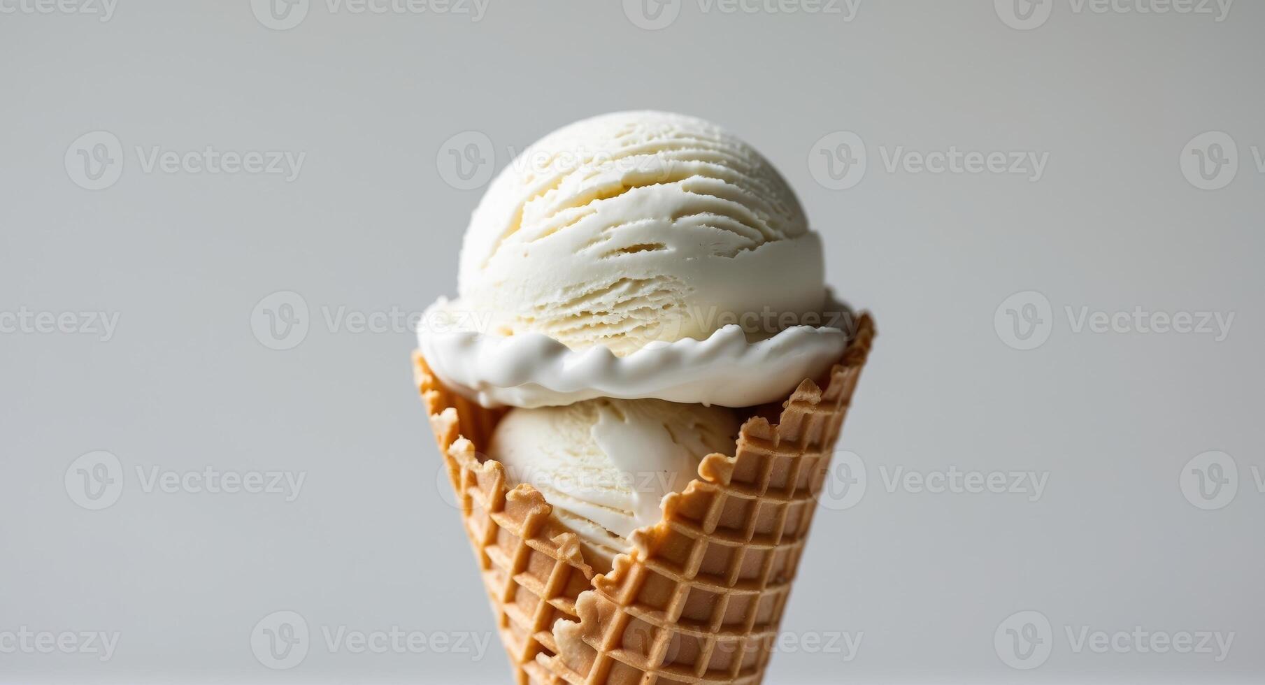 A delicious scoop of creamy white vanilla ice cream in a waffle cone. photo