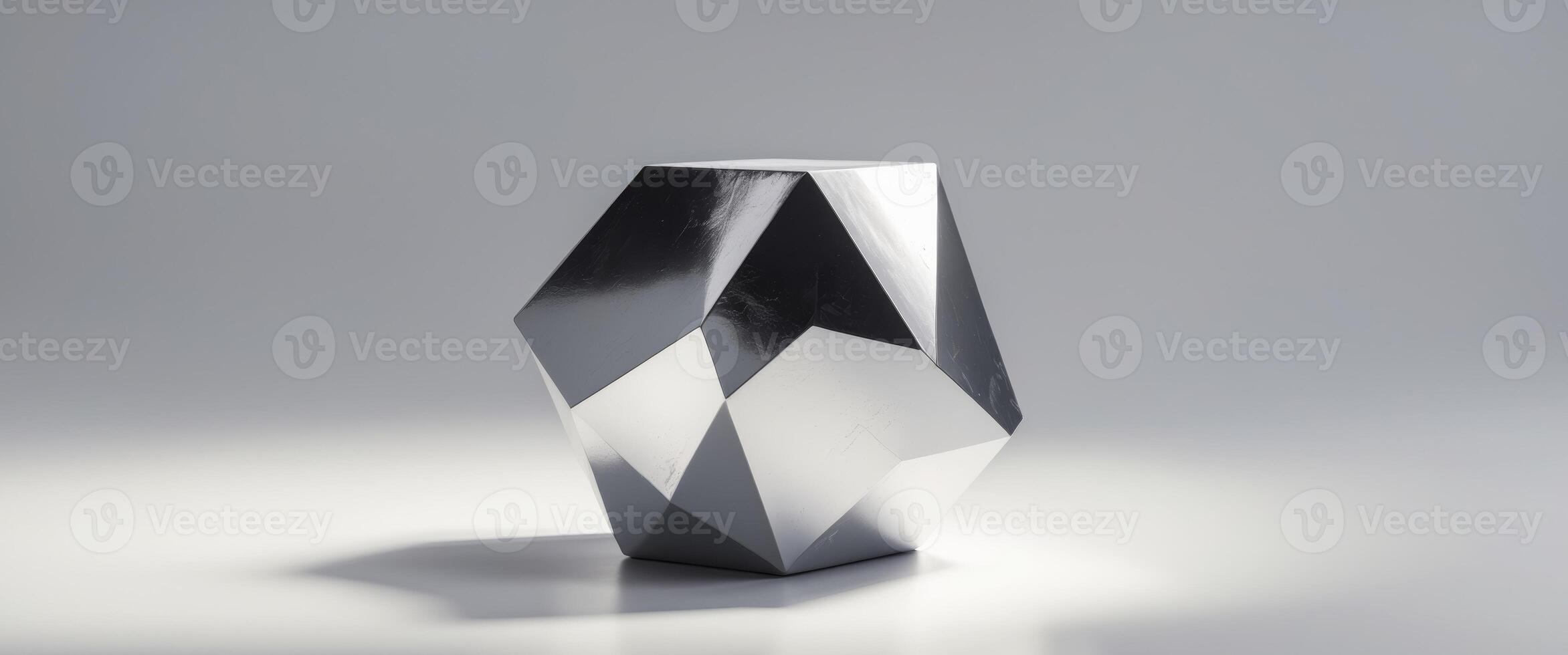 A faceted silver object rests on a flat surface photo