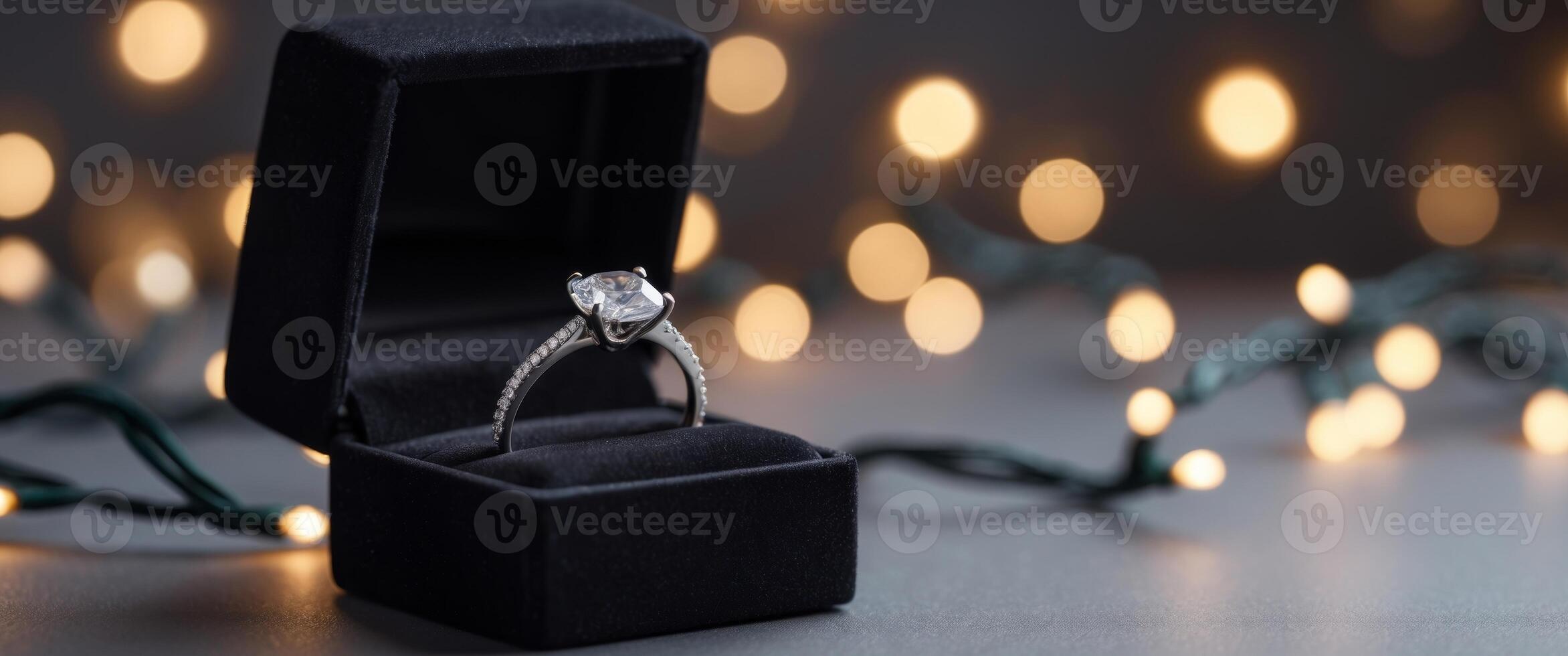 an engagement ring in a box with lights in the background. photo