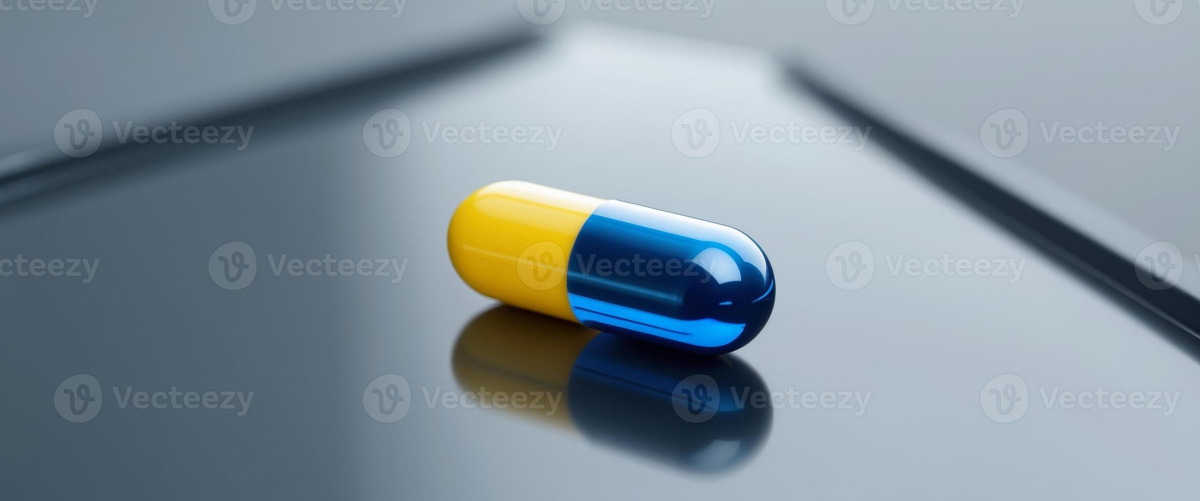 close up of a glossy blue and yellow pill capsule on reflective surface representing healthcare and medication with space for text. photo