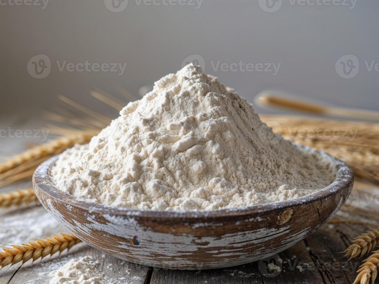 A bowl of flour and wheat on a wooden table photo