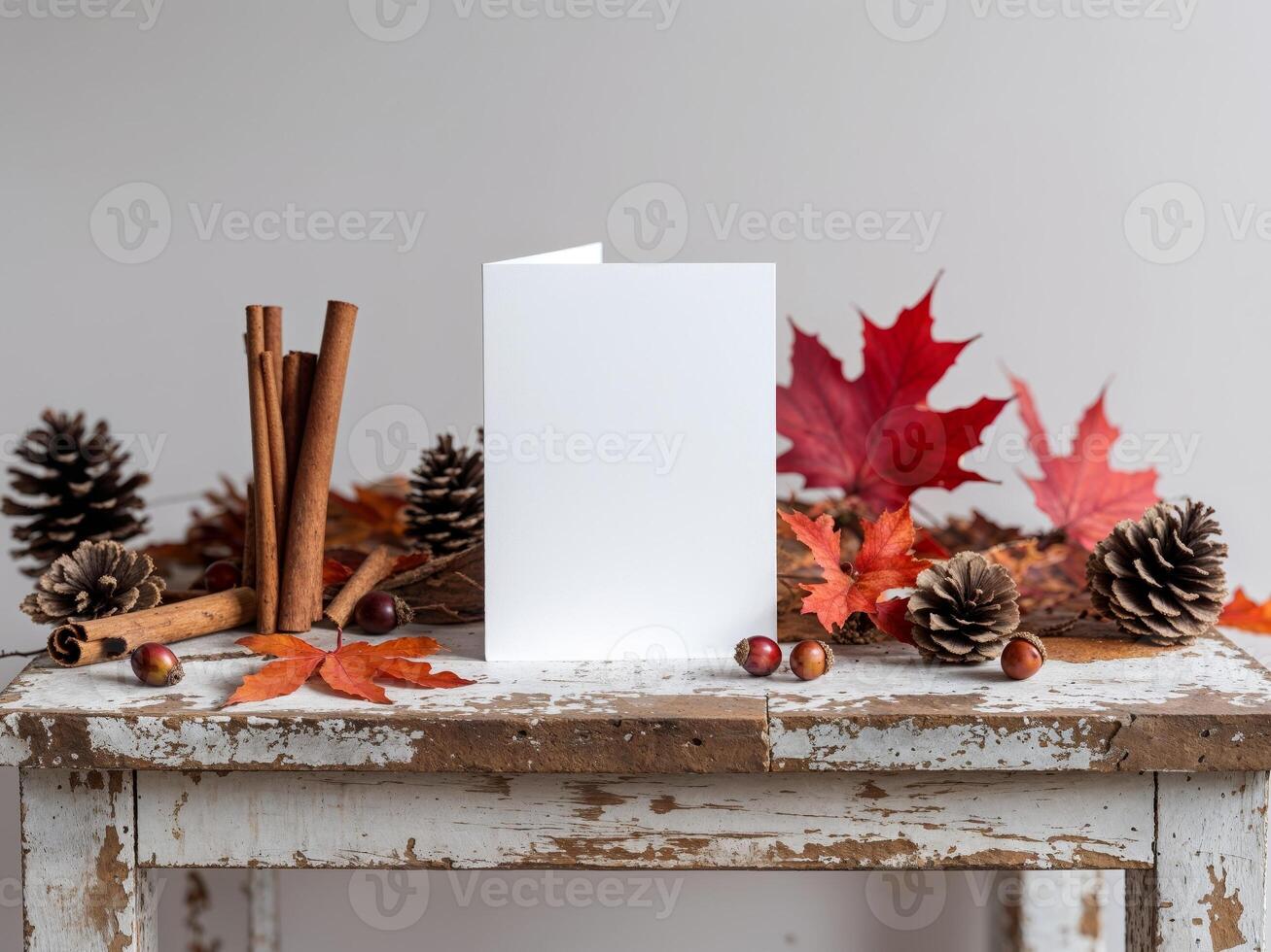 A blank card on a wooden table with autumn leaves and cinnamon photo