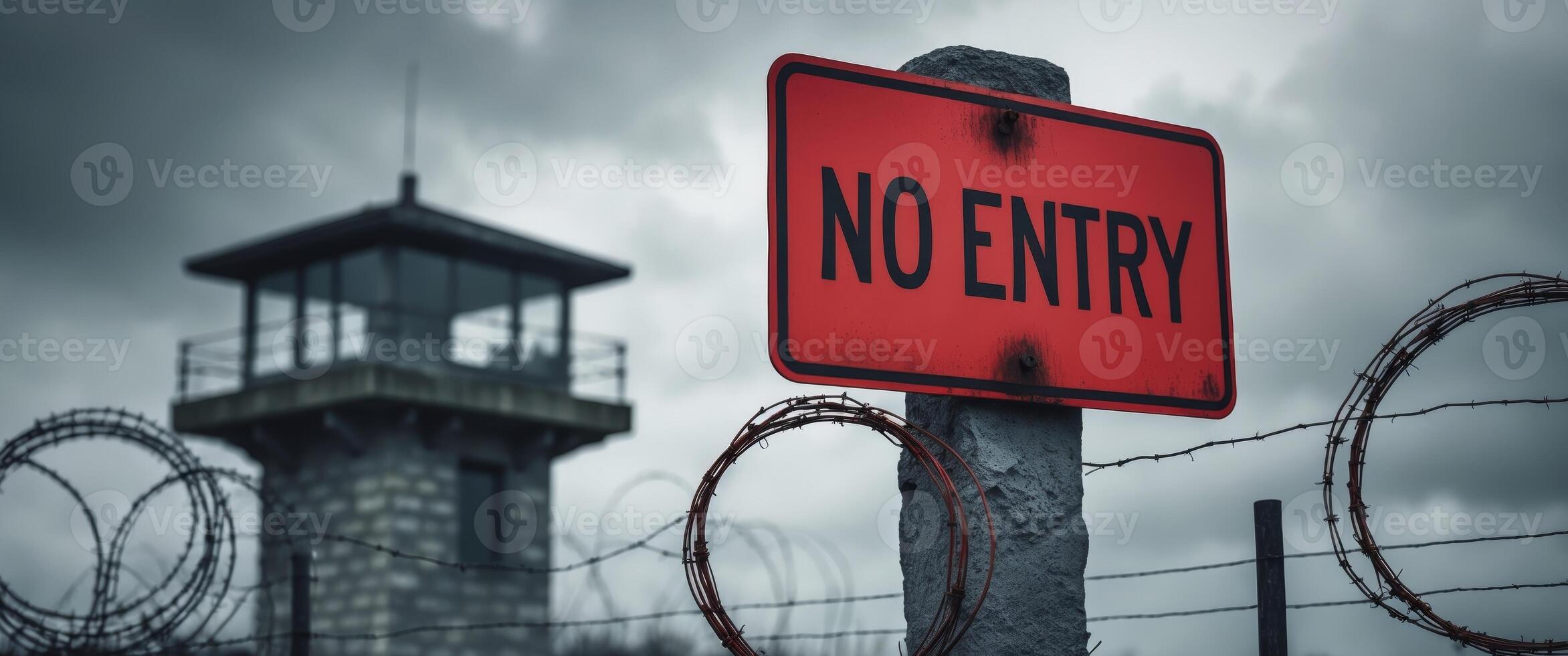 A no entry sign is seen next to barbed wire photo