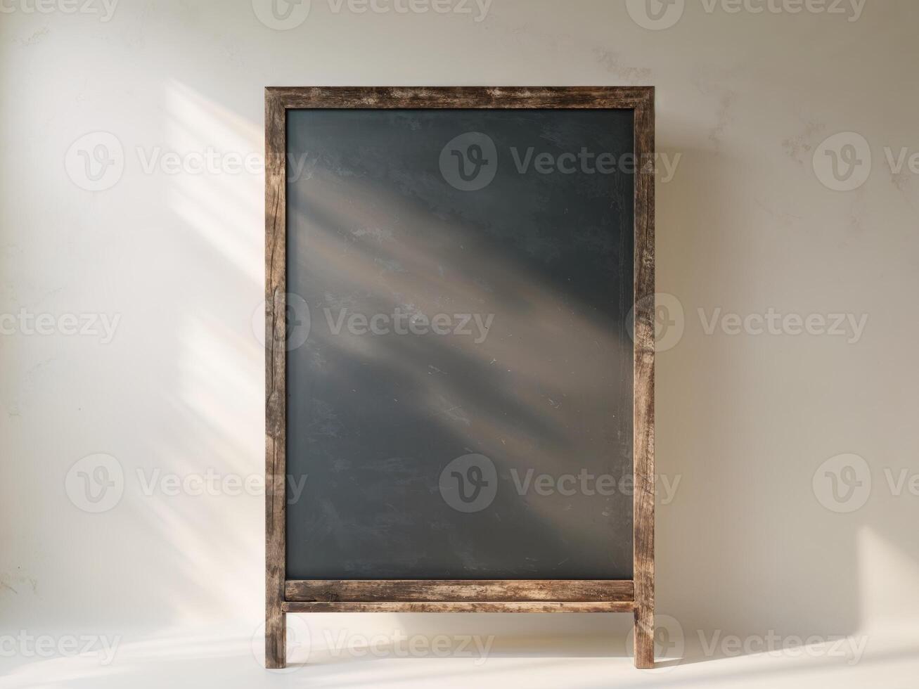 A blank blackboard with a wooden frame stands ready for classroom education. photo