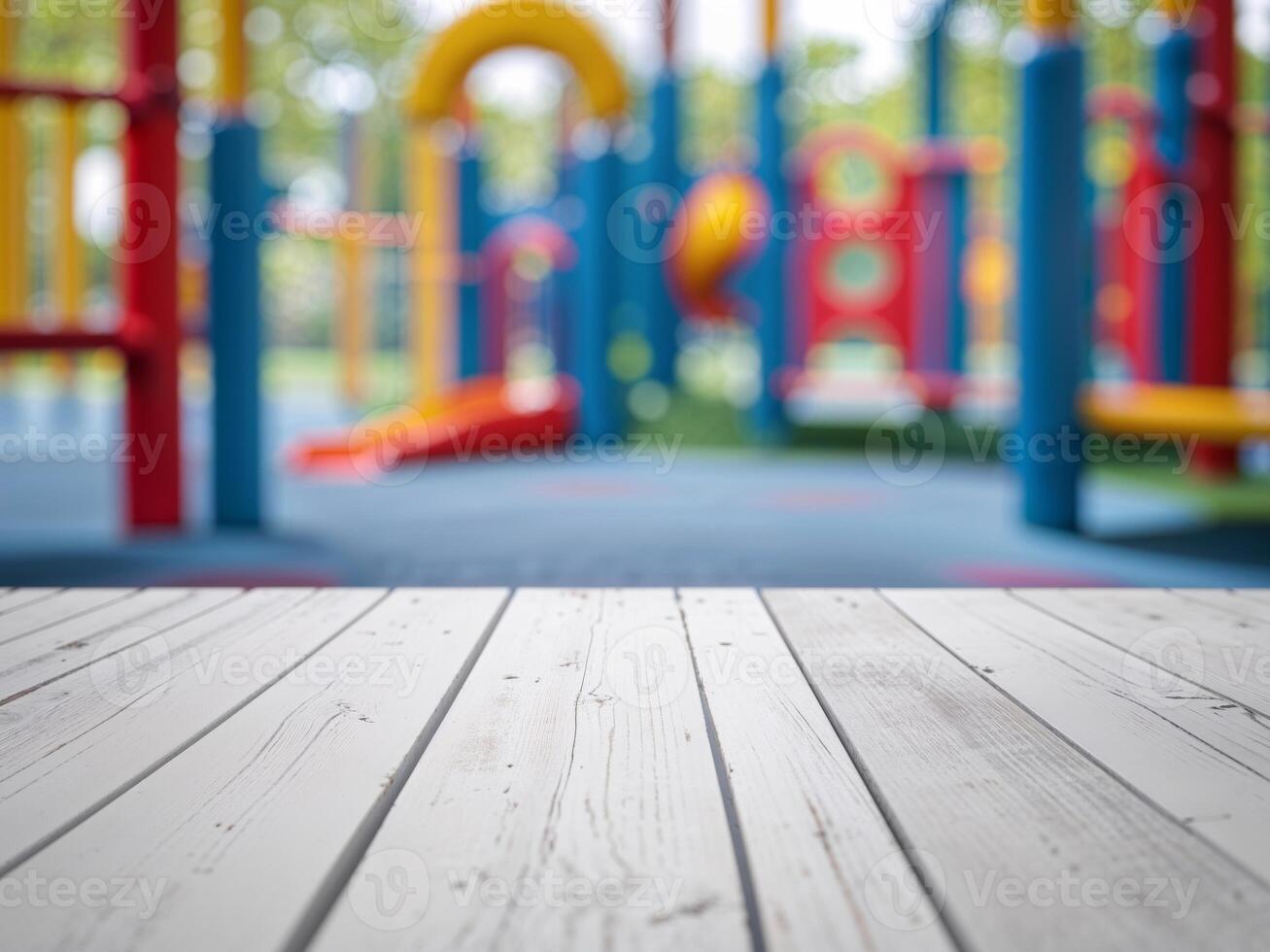 Empty white wooden tabletop on blurred background of bright colorful children playground. photo