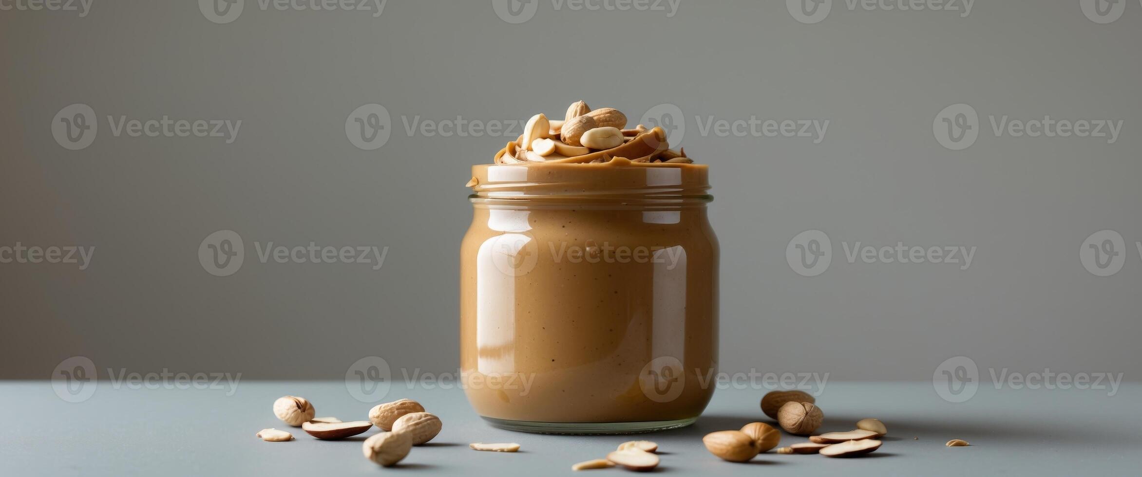 Peanut Butter in Glass Jar with Peanuts and Almonds photo