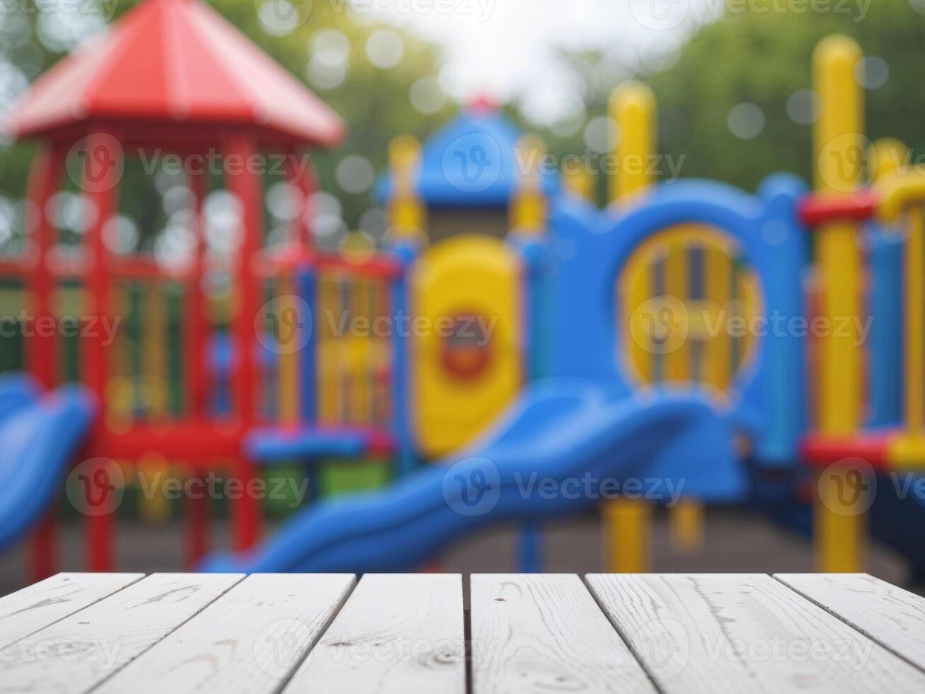 Empty white wooden tabletop on blurred background of bright colorful children playground photo
