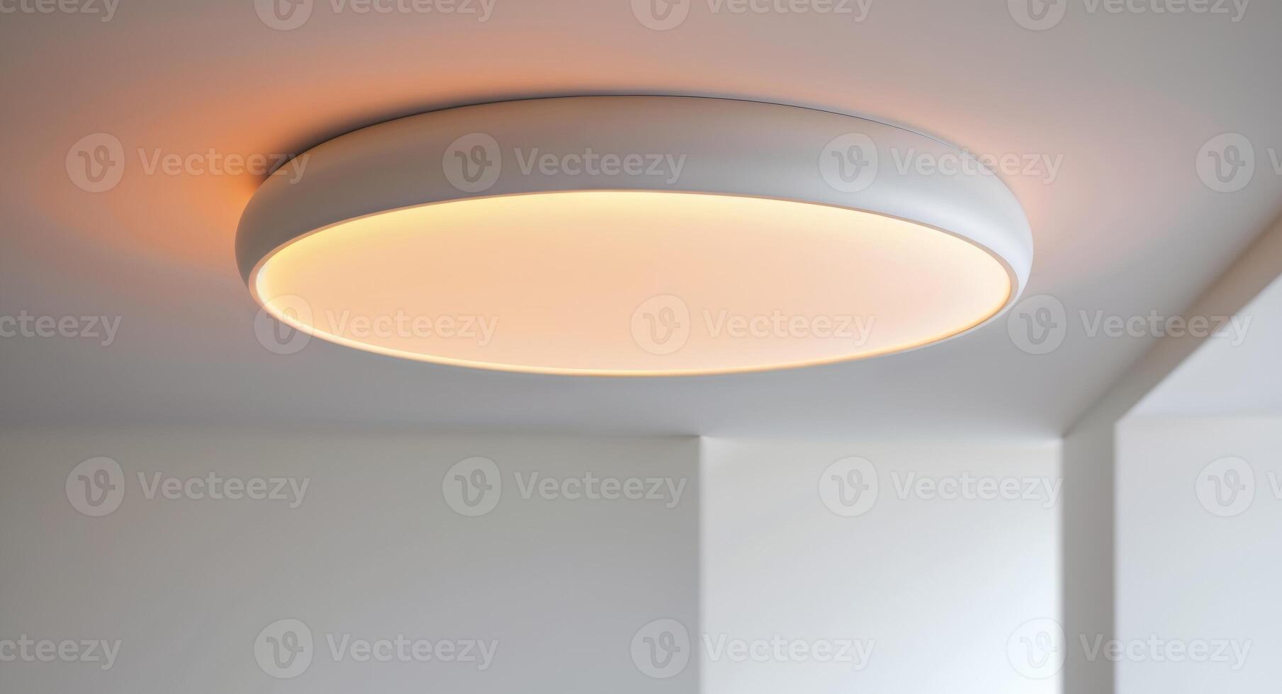 White circular ceiling lamp with an integrated motion sensor emitting a warm orange light photo