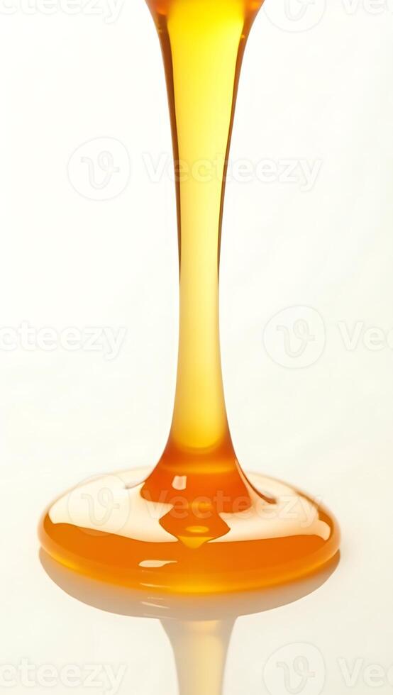 Extreme closeup of golden honey dripping from a spoon on a white surface photo