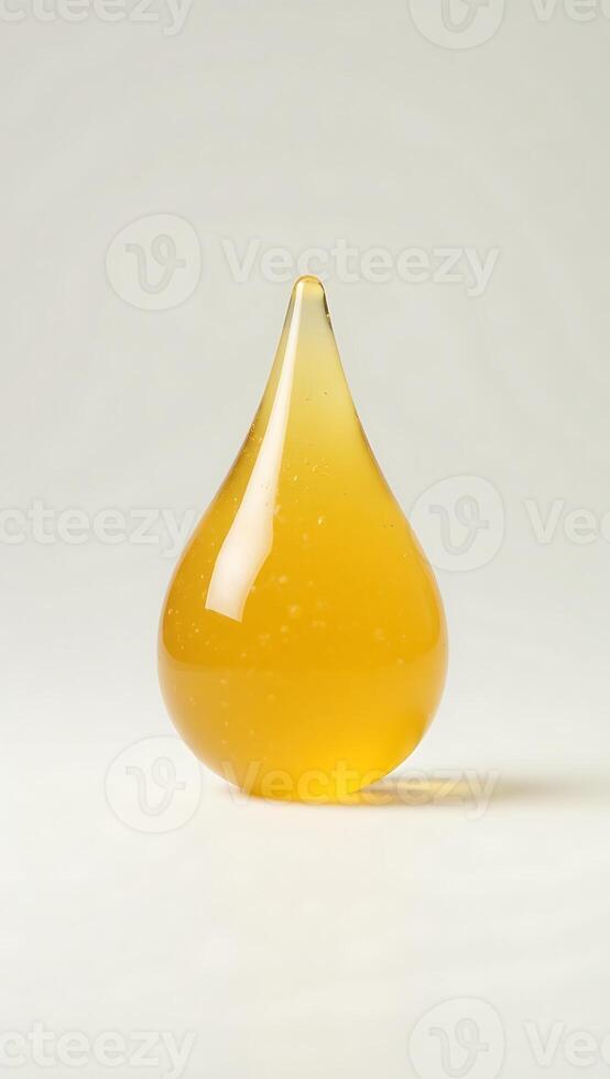 Closeup of a translucent yellow drop with a smooth finish set against a blank background photo