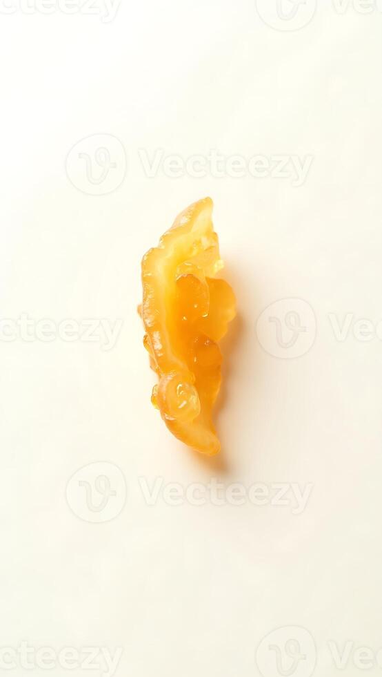 Closeup view of a single piece of amber colored resin on a light surface photo
