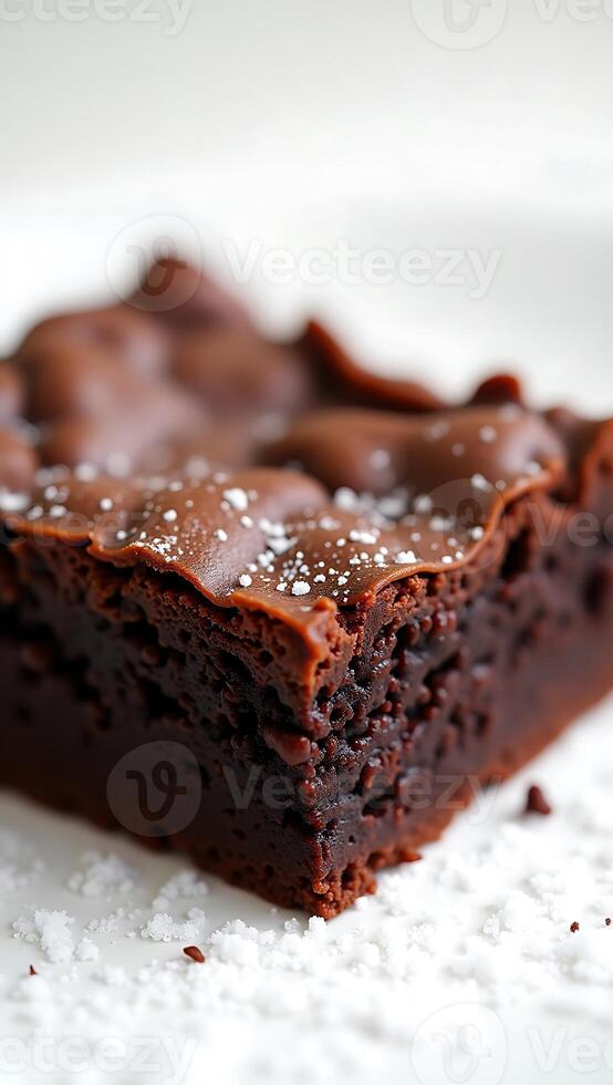 Closeup view of a chocolate brownie topped with powdered sugar on a white plate photo