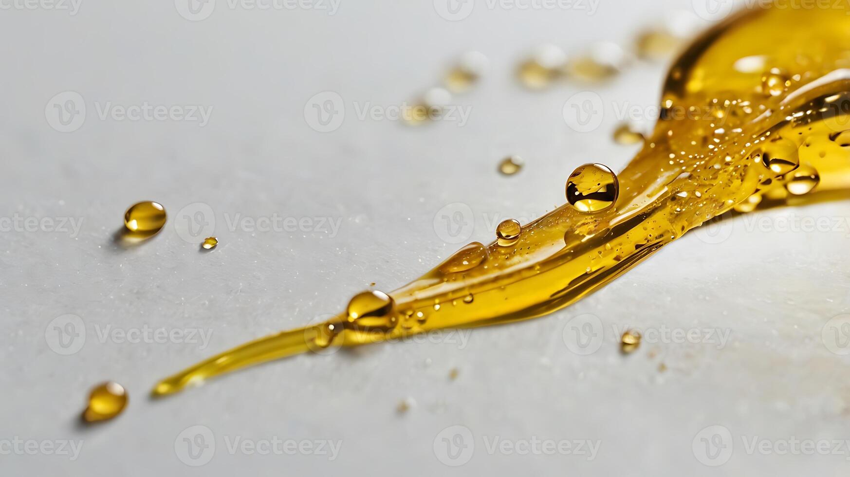 Closeup view of a single liquid droplet on a flat surface with golden hues shining through photo