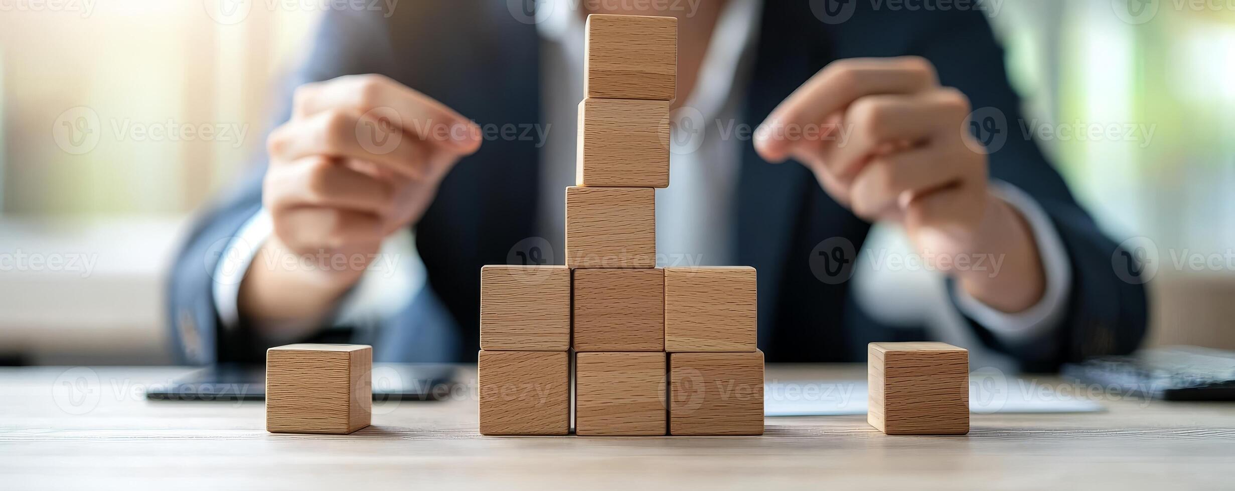 Climbing corporate ladder concept. Building blocks arranged on a table with hands strategically placing them. photo