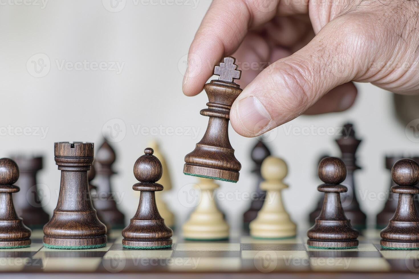 Hand moving a wooden chess piece during a strategic game on a chessboard. photo