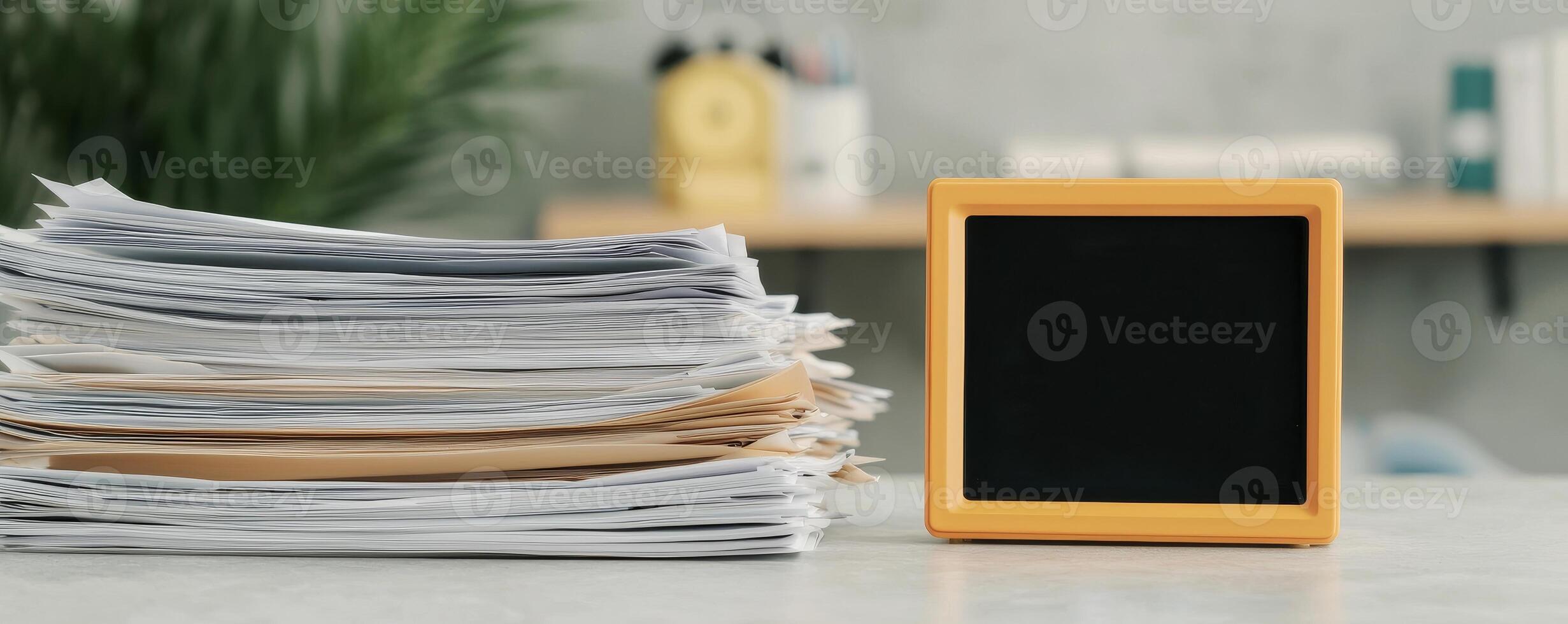 Stack of documents beside a chalkboard in a modern workspace. photo