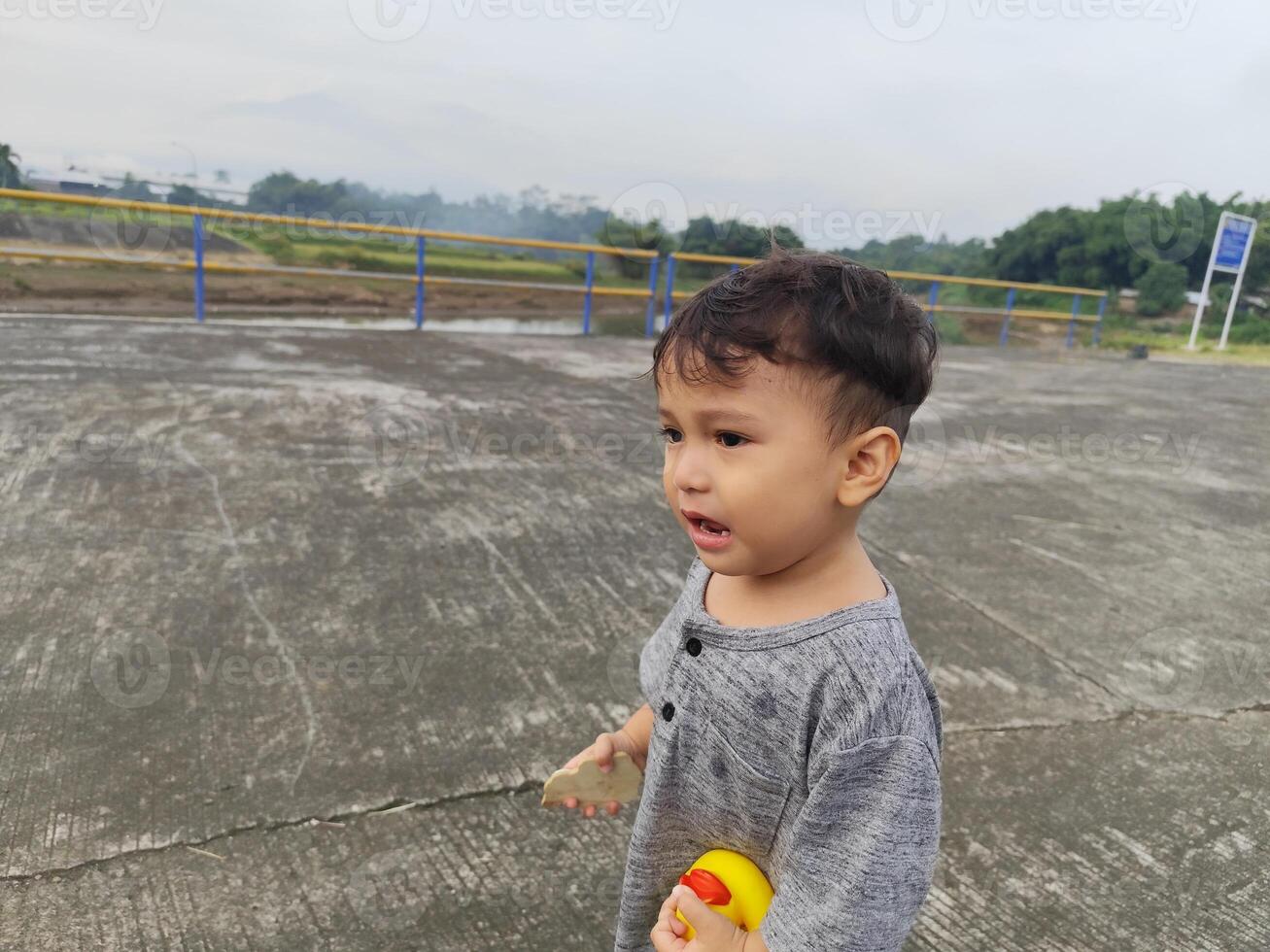 Cheerful Asian Child Playing Barefoot on Green Lawn in the Yard photo