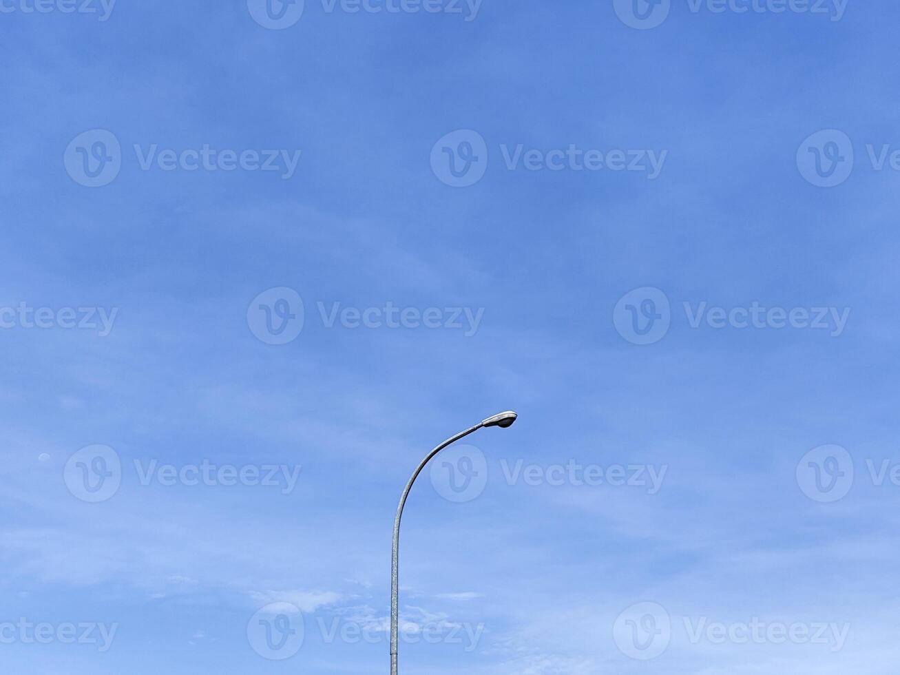 Urban Streetlight Silhouette Against a Vibrant Blue Sky photo