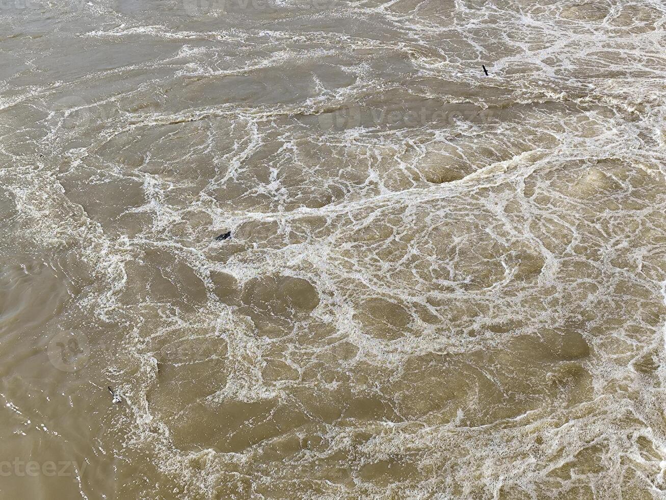 Turbulent Water Surface with Floating White Foam Patterns photo