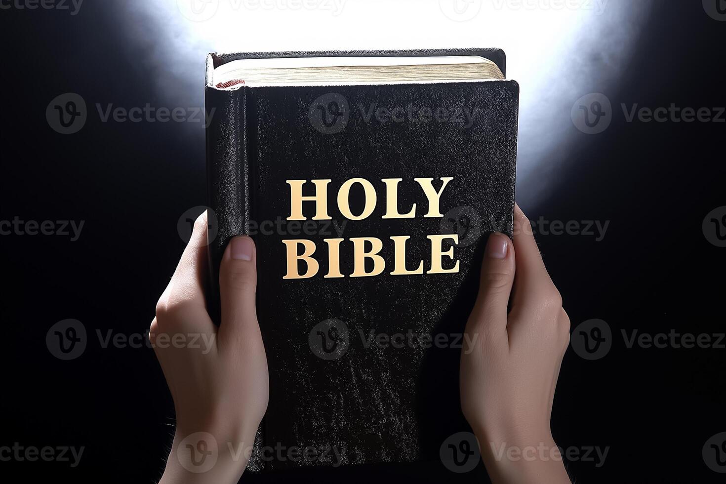 Holy bible in hands with light shining on it photo